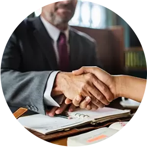 A man in a suit and tie is shaking hands with a woman.