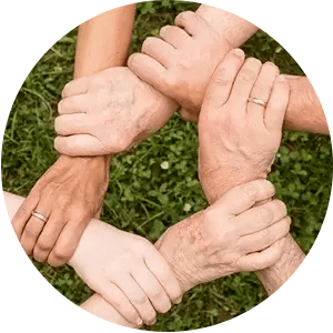 A group of people are putting their hands together in a circle.