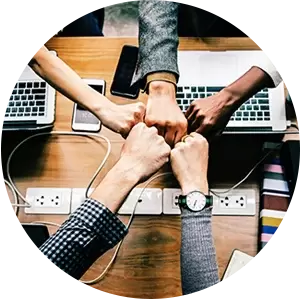 A group of people are putting their hands together in a circle.