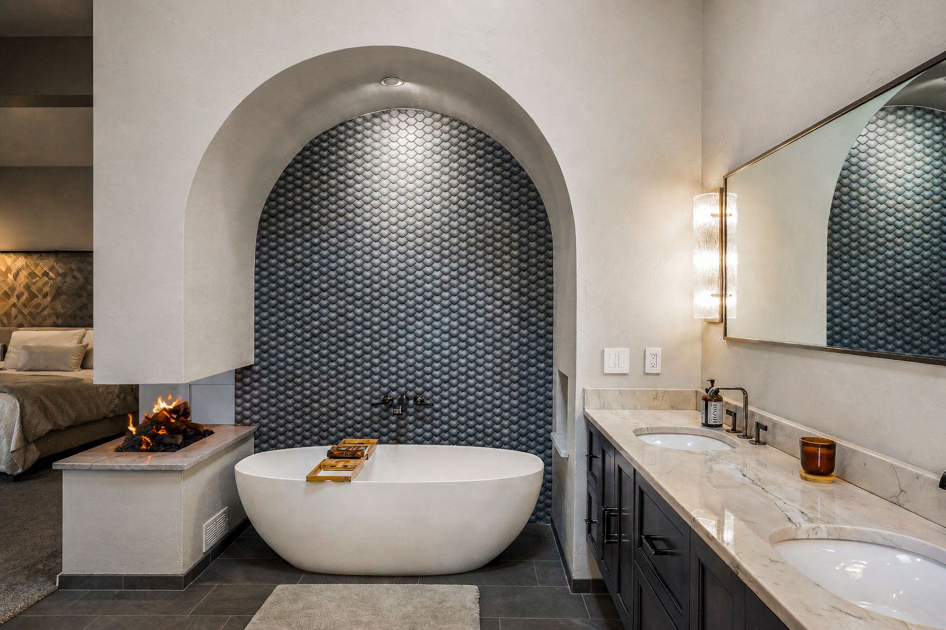Modern bathroom with mosaic arch shower, freestanding tub, double vanity, and lit mirror