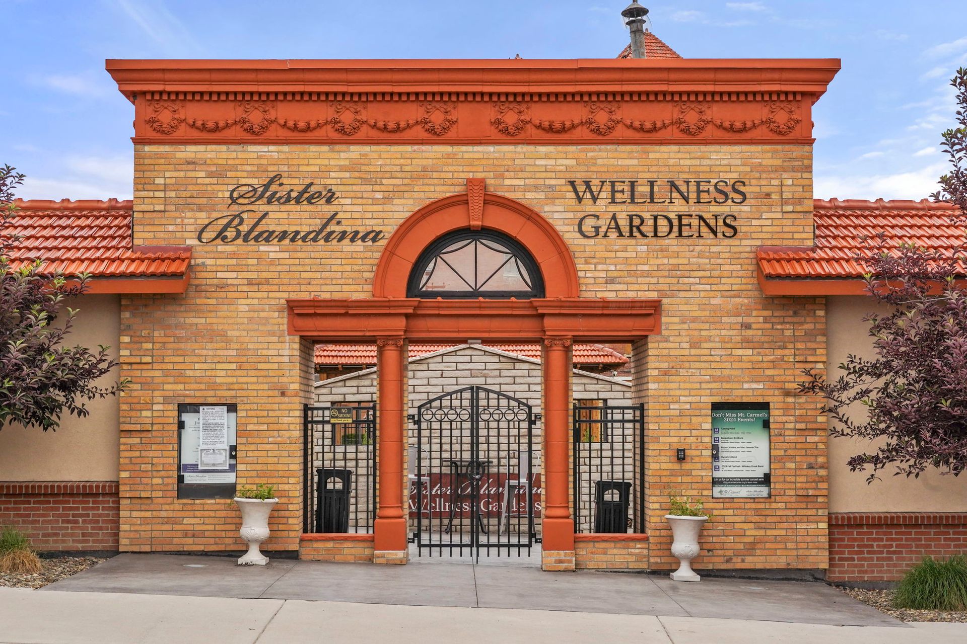 Wellness Gardens storefront with orange-brick facade, arched entry, and gated entrance