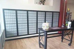 Black folding room divider behind a dark table on a light wood floor in a bright room