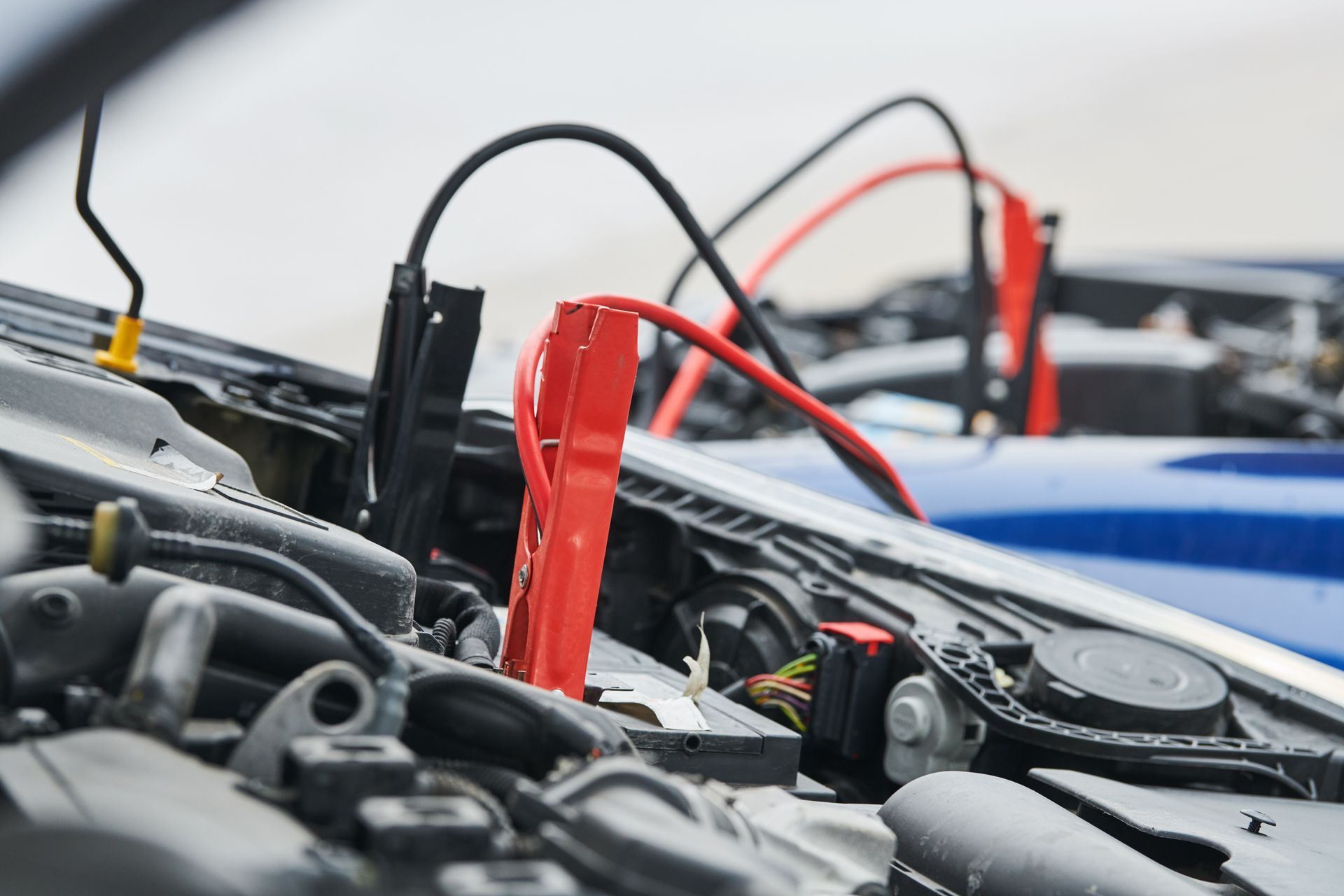 Jumper cables connected to two car batteries.