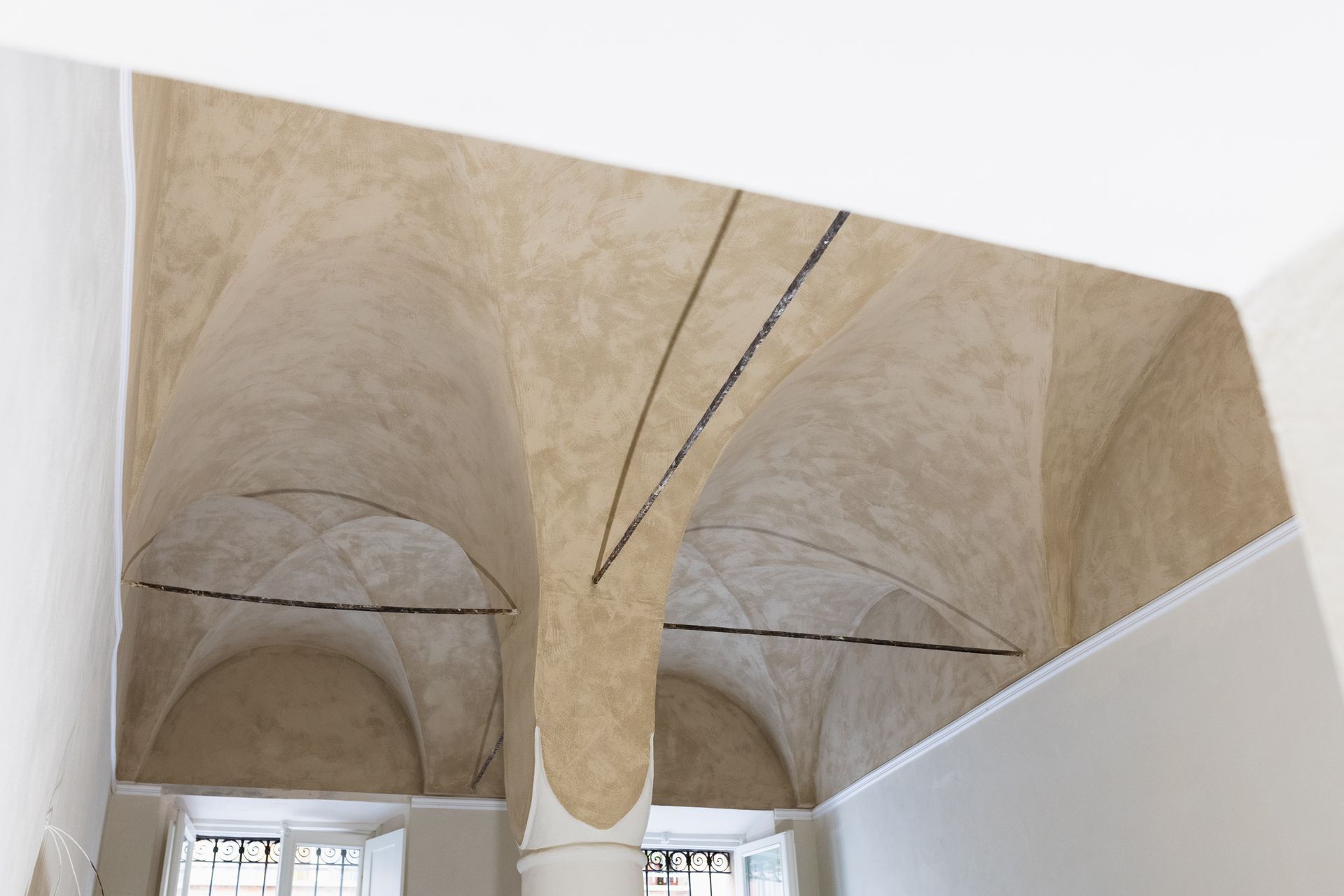 Soffitto a volta in pietra con archi e finestre in un interno storico
