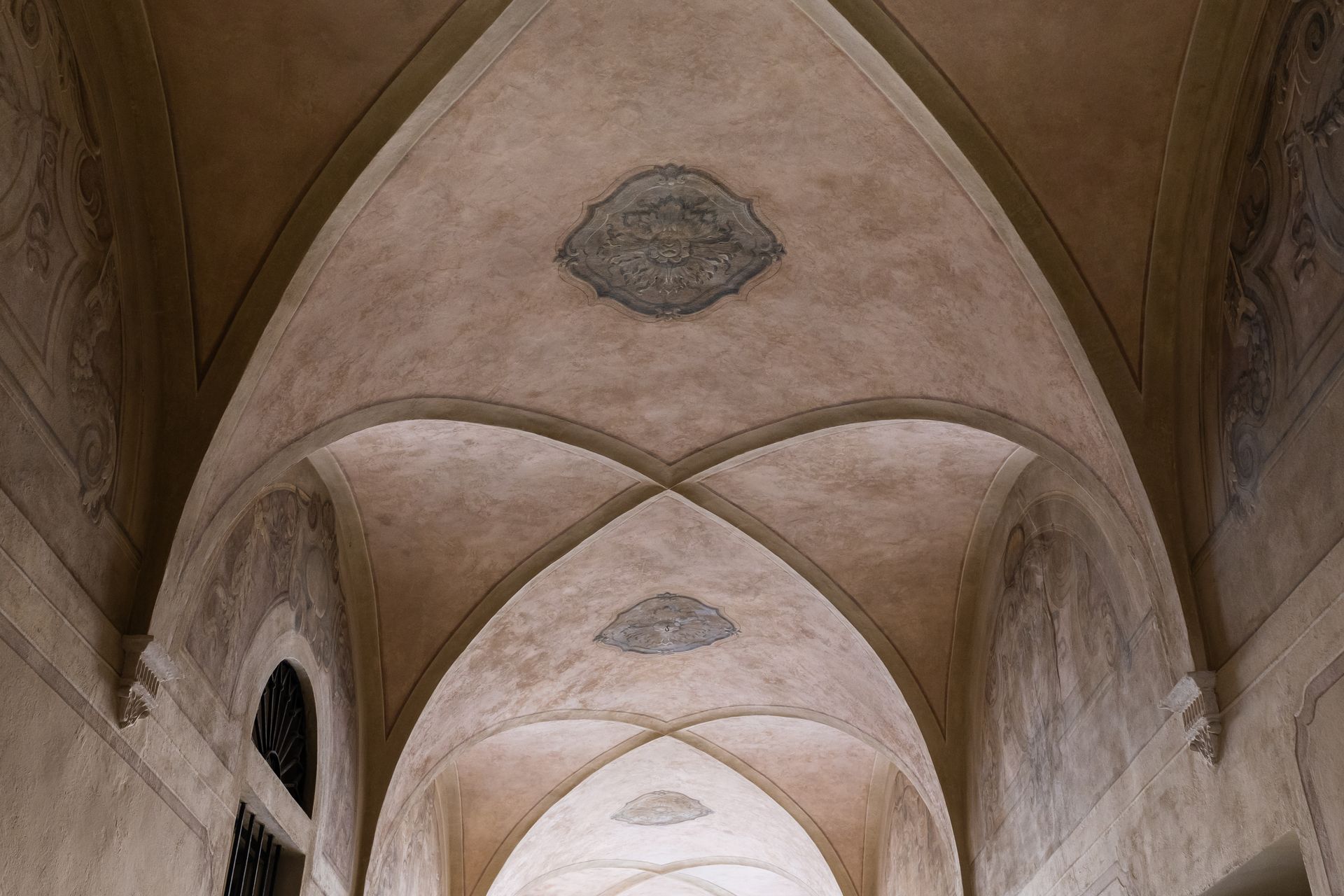 Soffitto della chiesa a volta in pietra con archi a sesto acuto e medaglioni decorativi sbiaditi