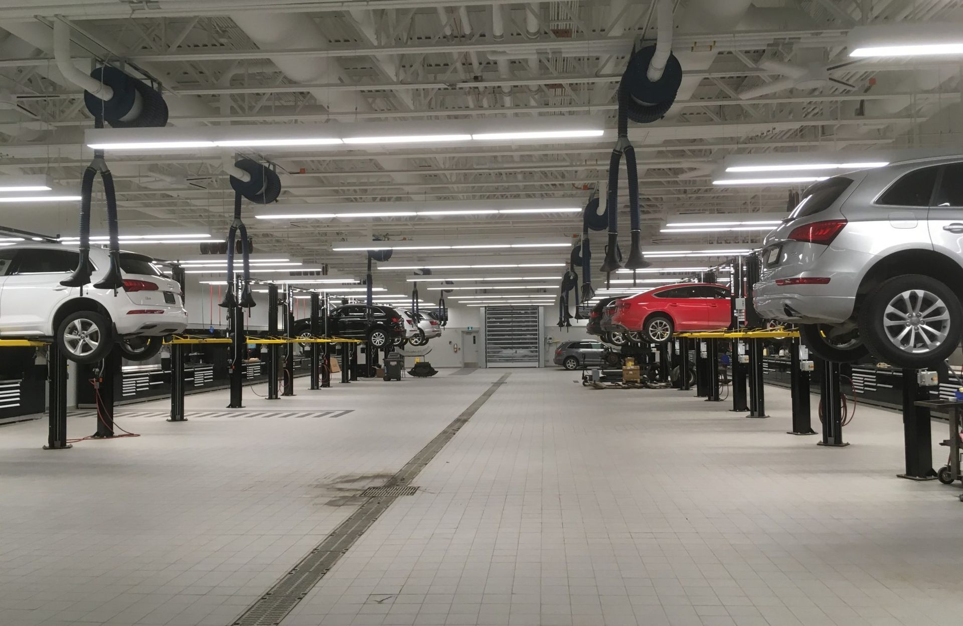 Une rangée de voitures sont assises sur des ascenseurs dans un garage.