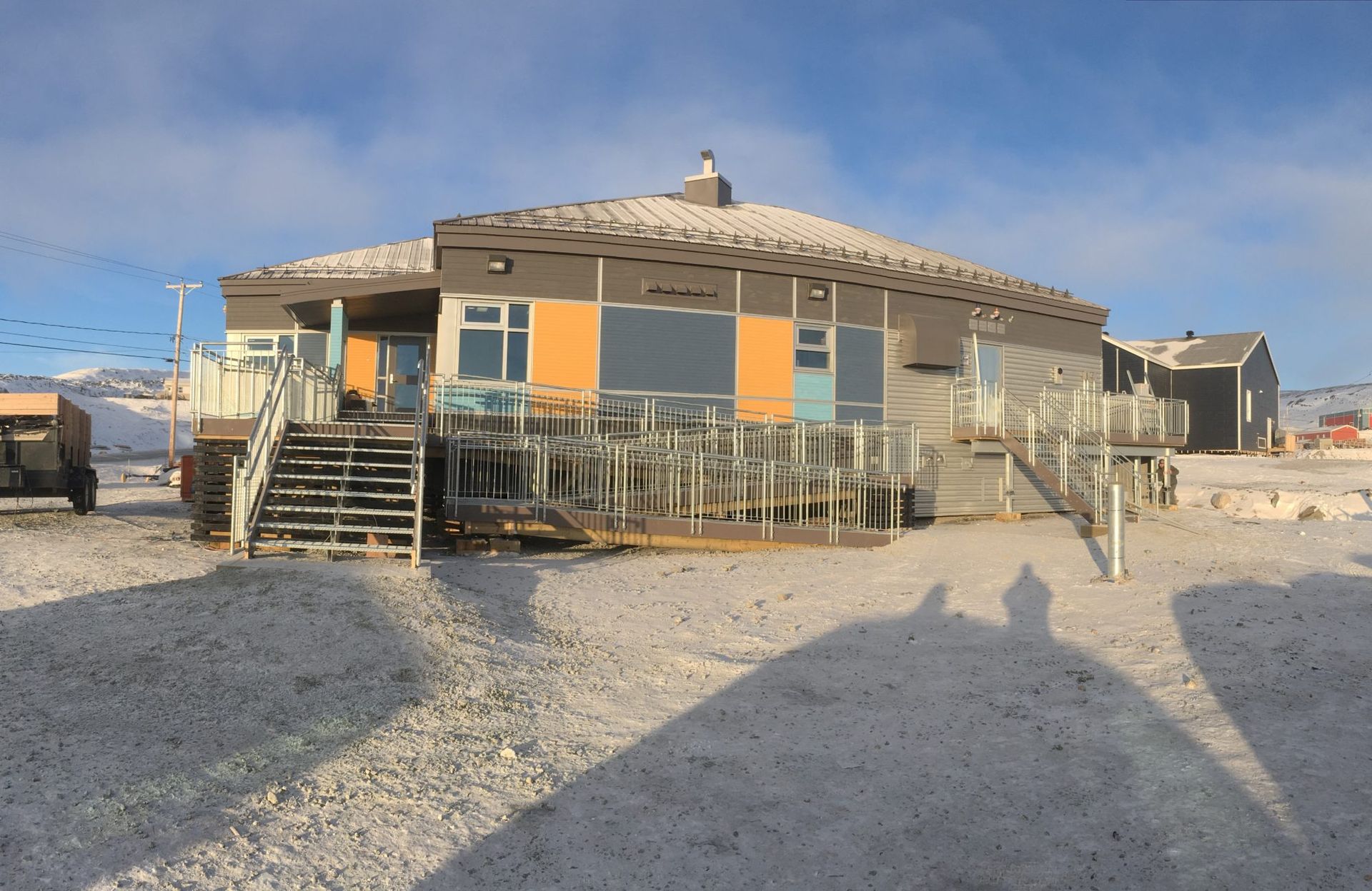 L'ombre d'une personne est projetée sur le sol devant une maison
