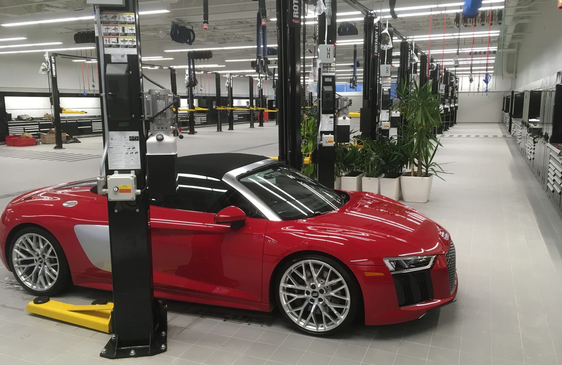 Une voiture de sport rouge est garée sur un ascenseur dans un garage.