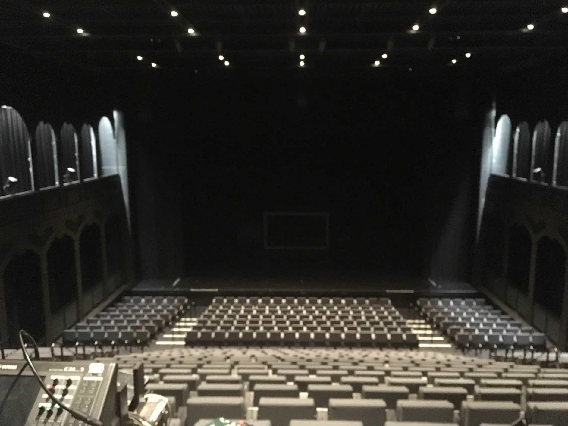 Un auditorium vide avec des rangées de sièges et une scène