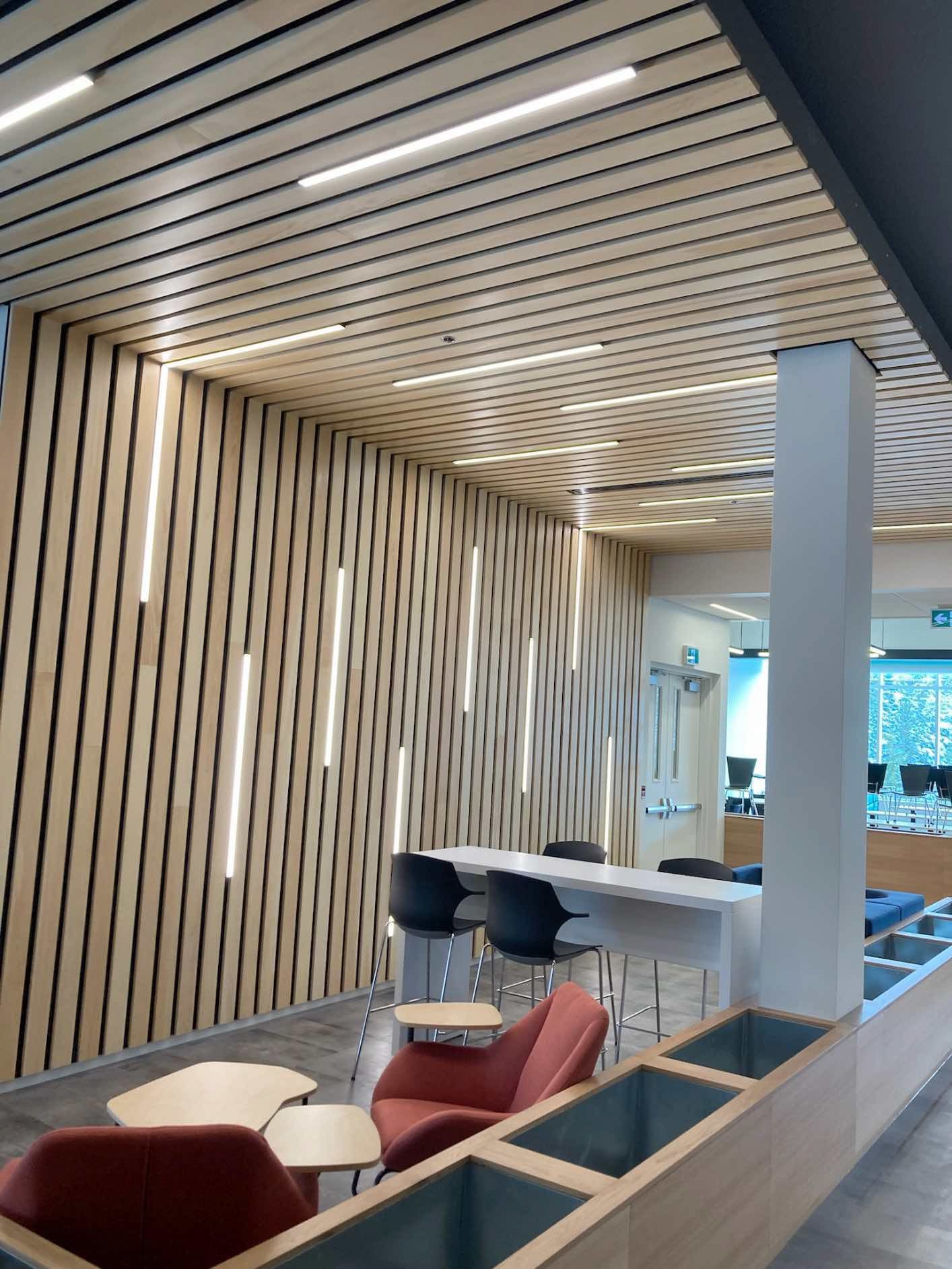 Une pièce avec un mur en bois et des tables et des chaises