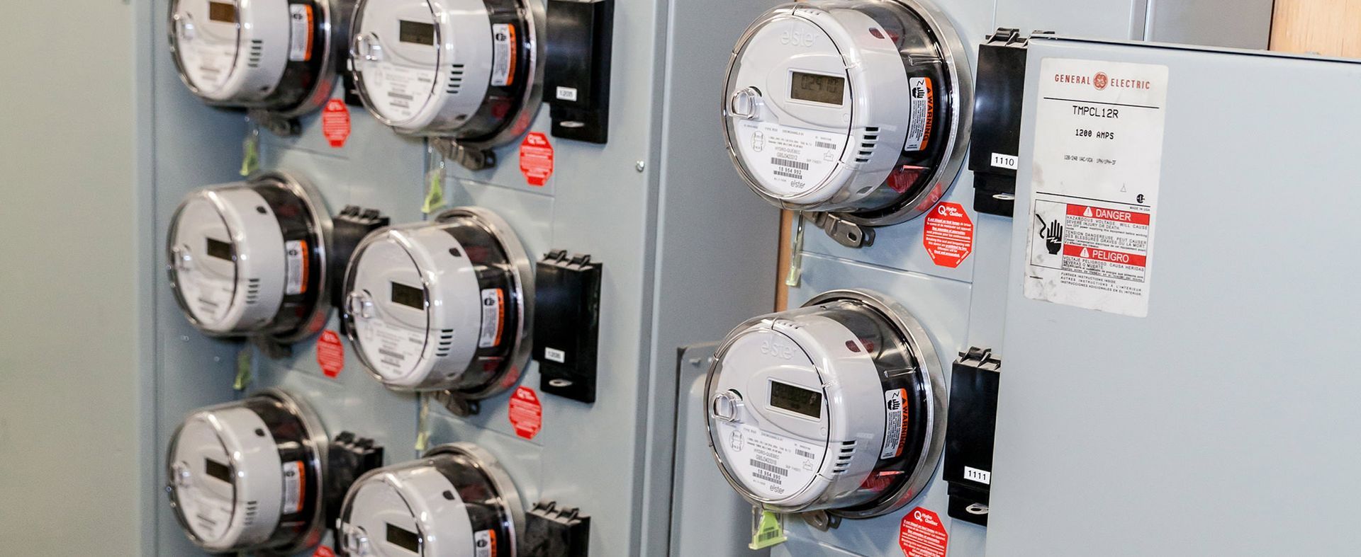 Un tas de compteurs électriques sont accrochés au mur.