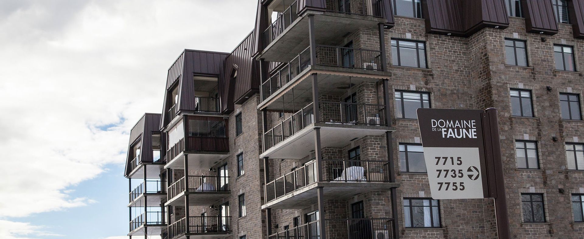 Un grand bâtiment en brique avec une pancarte sur le côté qui dit « appartements ».