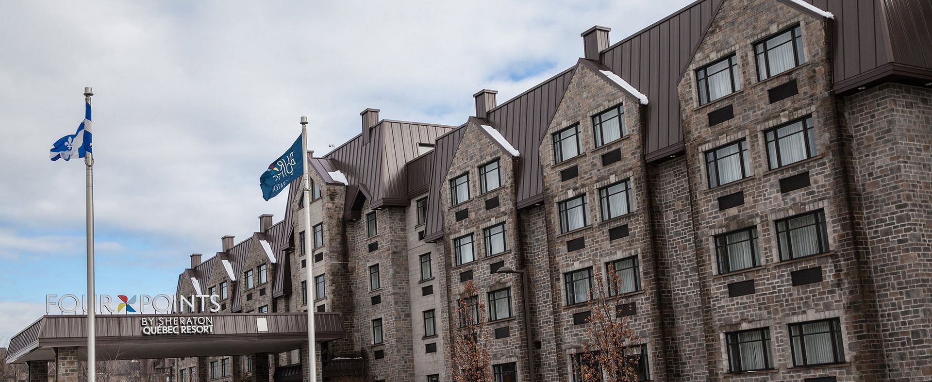 Un grand bâtiment en pierre avec des drapeaux flottant devant lui.