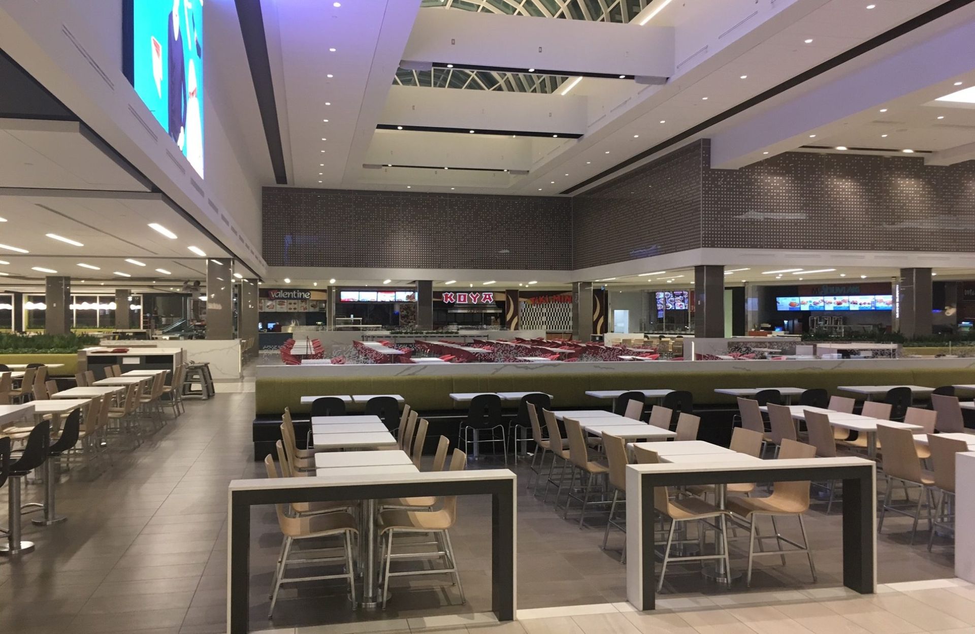 Une aire de restauration vide dans un centre commercial avec des tables et des chaises