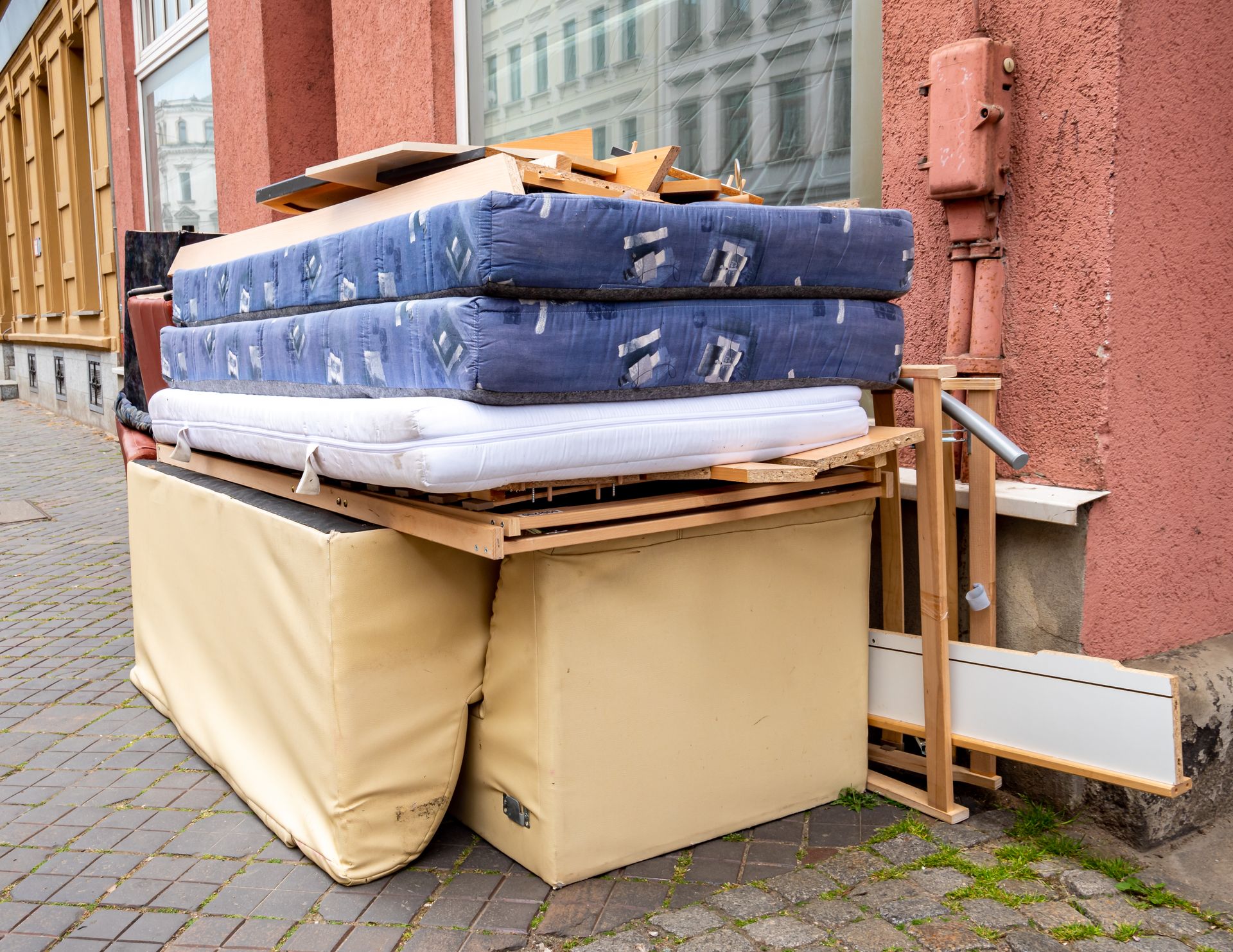 A row of green trash cans are lined up on the sidewalk