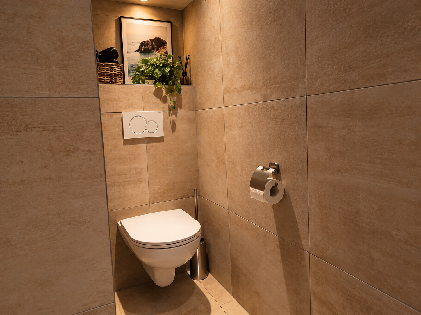 Compacte badkamer met beige tegels, een wandtoilet en een toiletrolhouder.