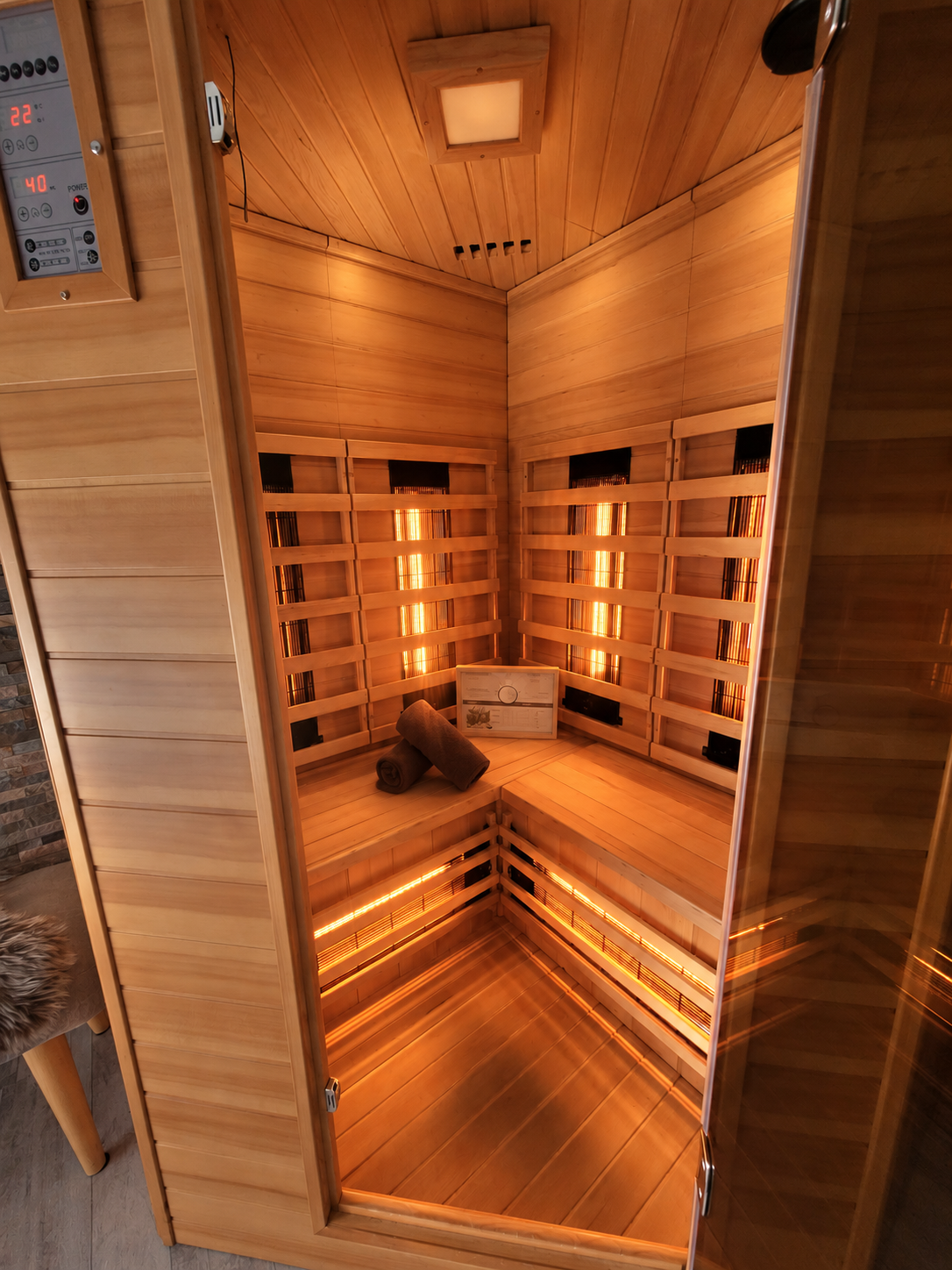 Infraroodsauna met houten lambrisering, sfeervolle verlichting en zitbanken.