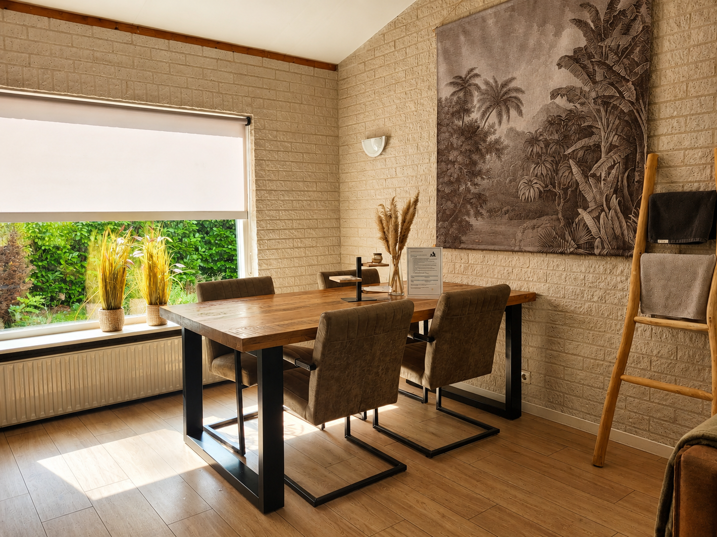 Zonnige eethoek met tafel, vier stoelen, groot raam en wanddecoratie met palmbomen.