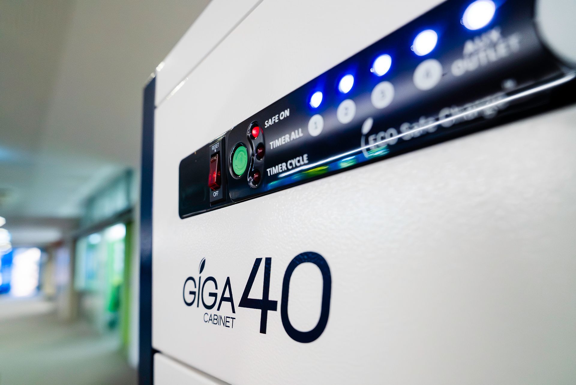 Close-up of a GIGA 40 device panel with blue indicator lights in a hallway