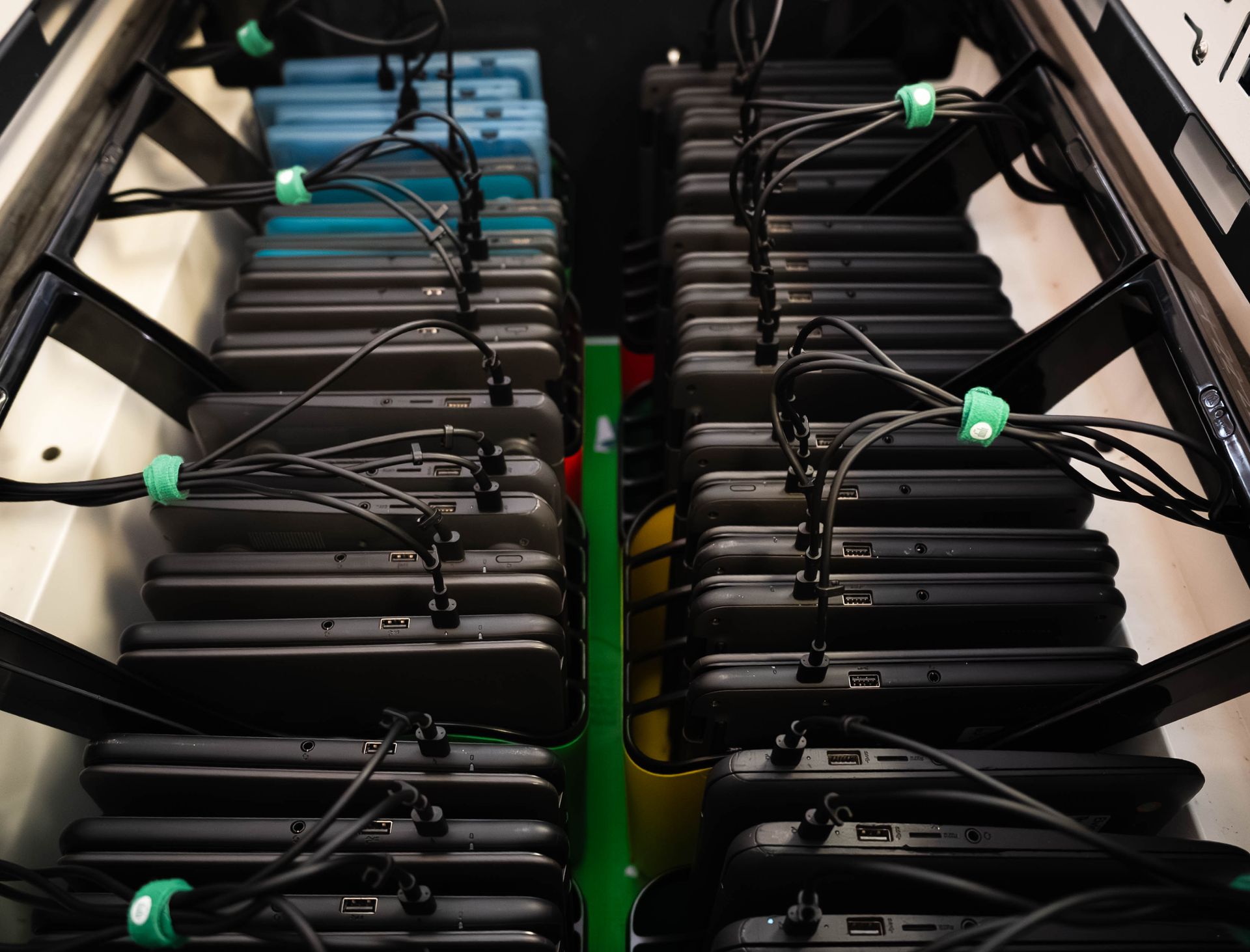 Rows of black battery packs with cables inside a server rack, viewed from above.