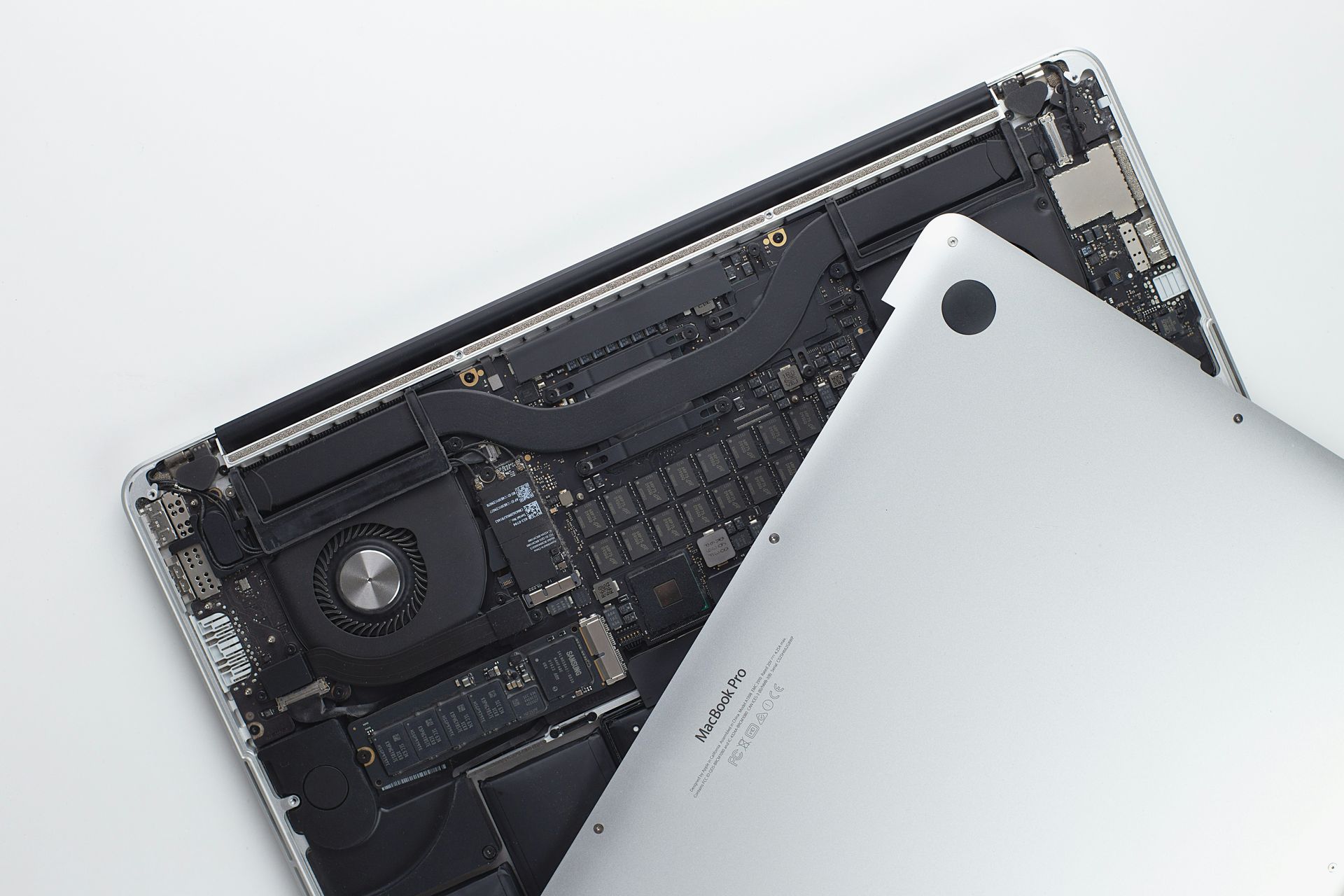 Disassembled laptop showing internal components with the white back cover partially removed