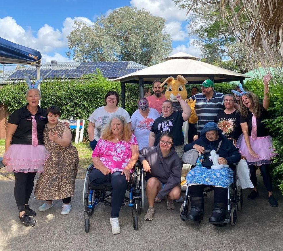 Easter event group photo. A group of people in wheelchairs and tutus are posing for a picture.