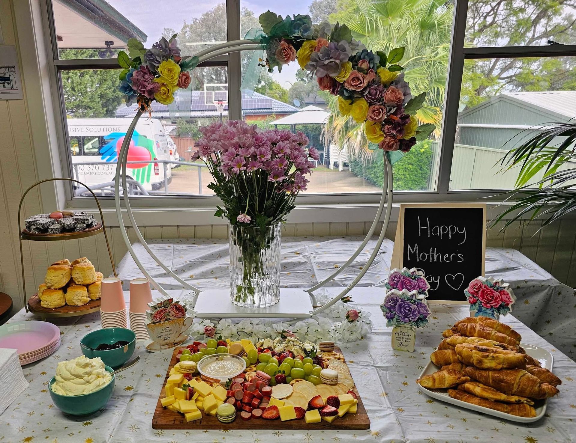 A table with a variety of food and flowers on it.