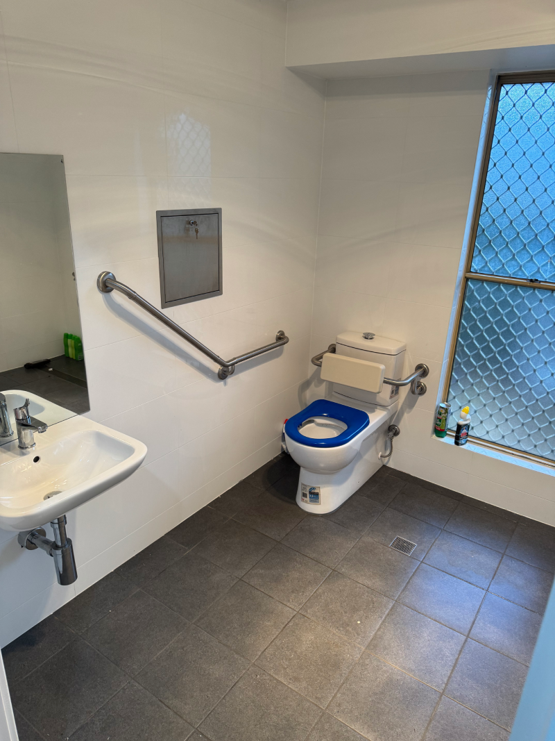 A bathroom with a toilet , sink and mirror