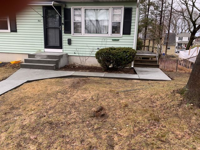 a house with a concrete walkway leading to the front door