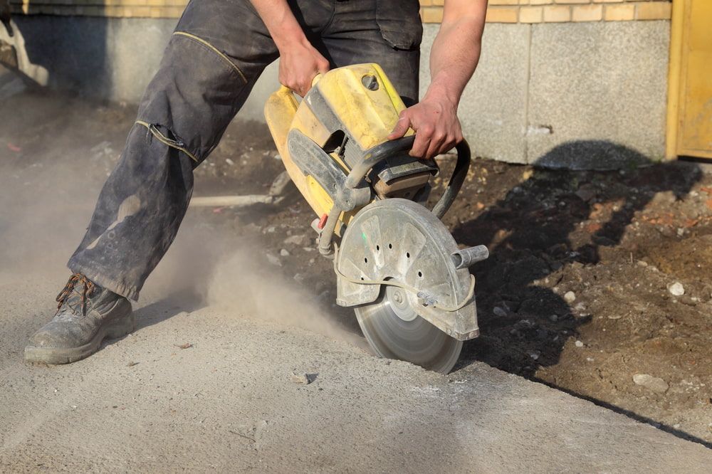A Man Is Using A Circular Saw To Cut Concrete — Pro Cut N Core In Manunda, QLD