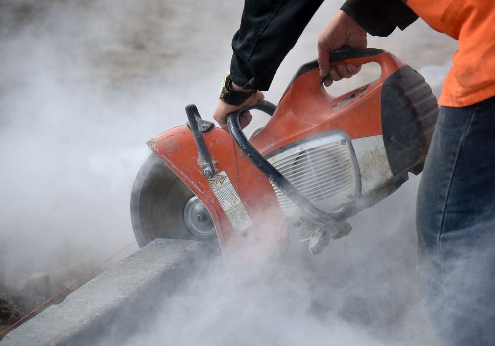 A Man Is Using A Circular Saw To Cut Concrete — Pro Cut N Core In Cairns, QLD