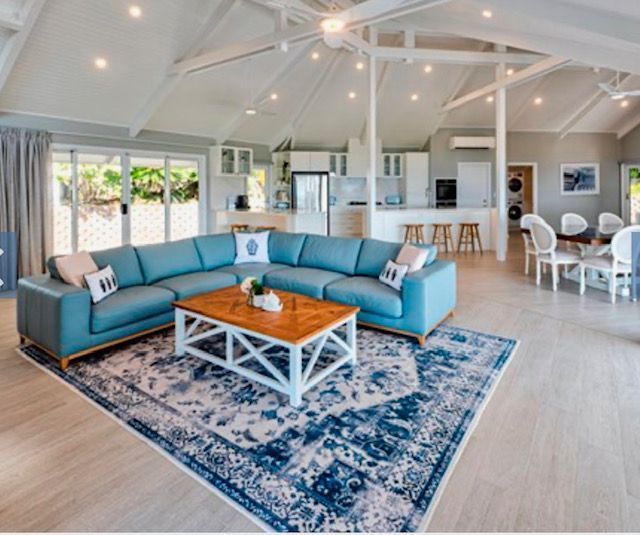 A Living Room With a Blue Sectional Couch and a Coffee Table — Coral Coast Building & Management in Cannon Valley, QLD