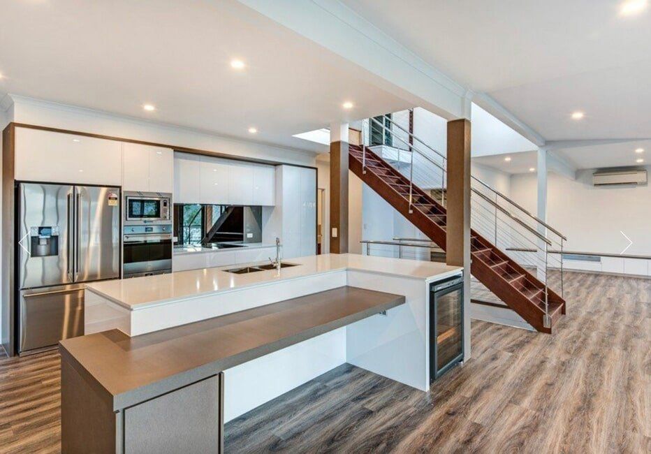 A Kitchen With a Staircase Leading Up to the Second Floor — Coral Coast Building & Management in Cannon Valley, QLD