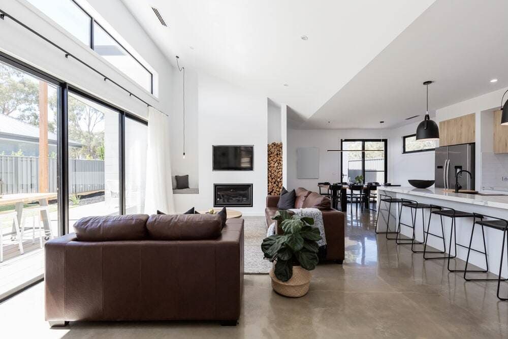 A Living Room With a Brown Couch and a Large Window — Coral Coast Building & Management in Cannon Valley, QLD