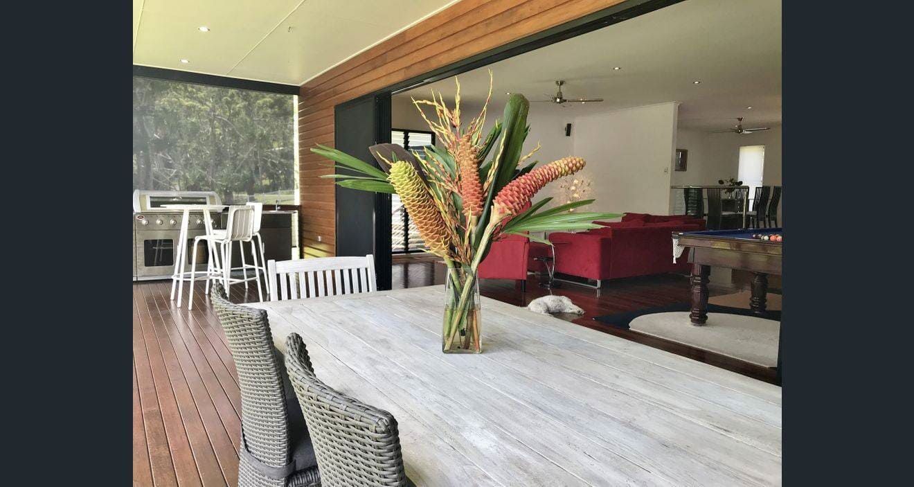 A Table With a Vase of Flowers on It in a Living Room — Coral Coast Building & Management in Cannon Valley, QLD