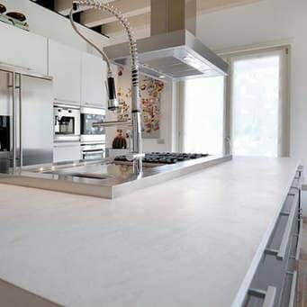 A Kitchen With White Cabinets , Stainless Steel Appliances , a Sink and a Stove Top Oven — Coral Coast Building & Management in Cannon Valley, QLD