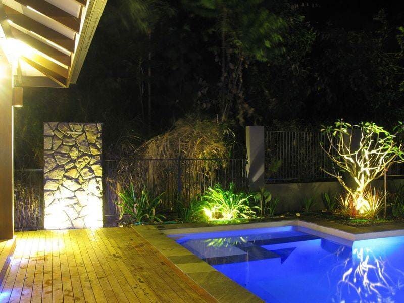 A Large Swimming Pool is Lit Up at Night — Coral Coast Building & Management in Cannon Valley, QLD