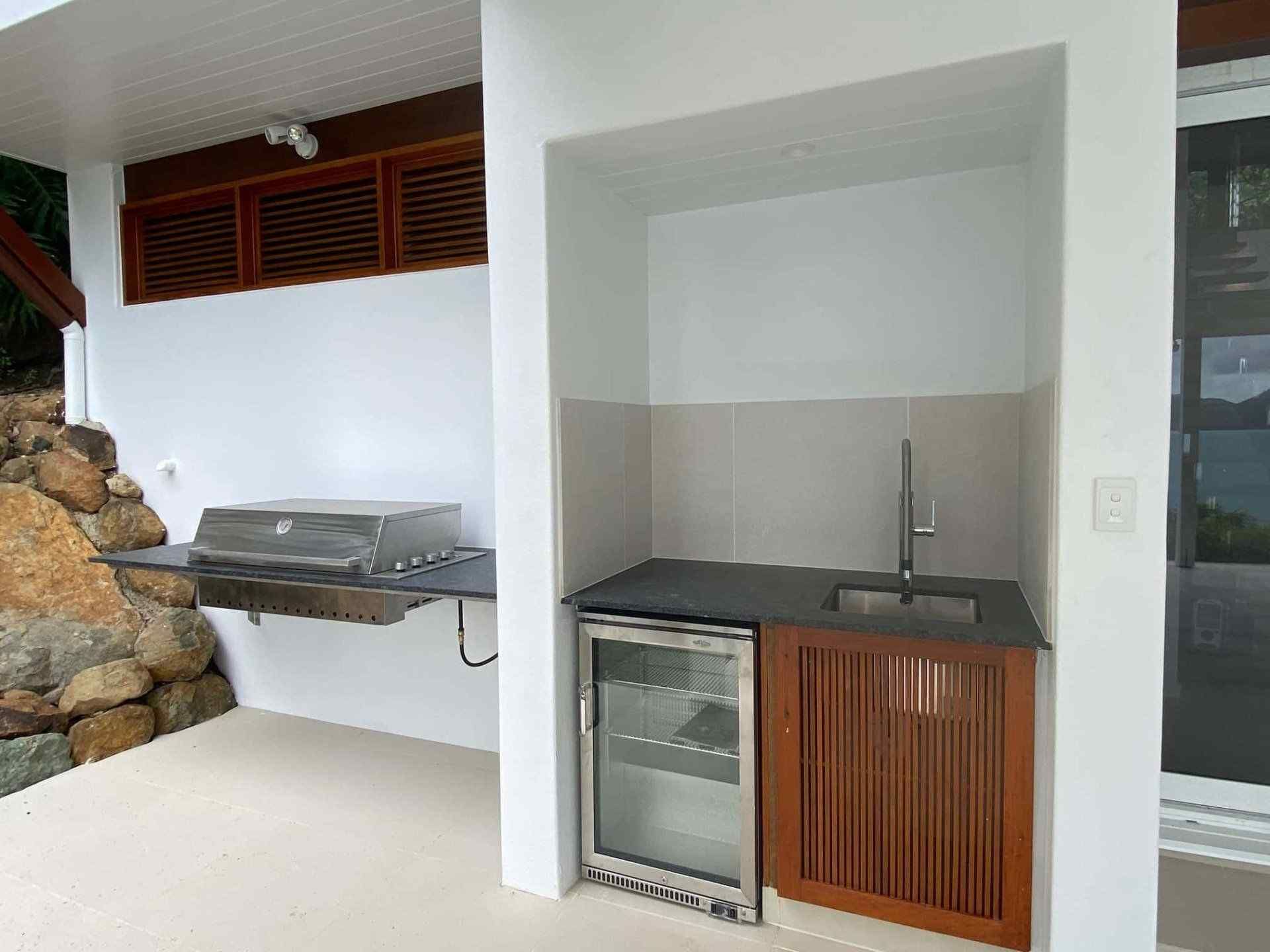 A Kitchen With a Grill , Sink and Refrigerator — Coral Coast Building & Management in Cannon Valley, QLD