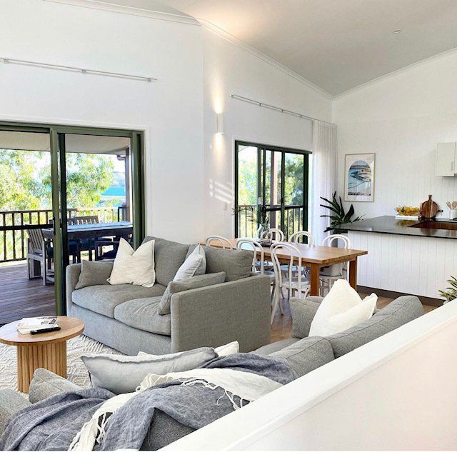 A Living Room With a Couch , Table and Chairs — Coral Coast Building & Management in Cannon Valley, QLD