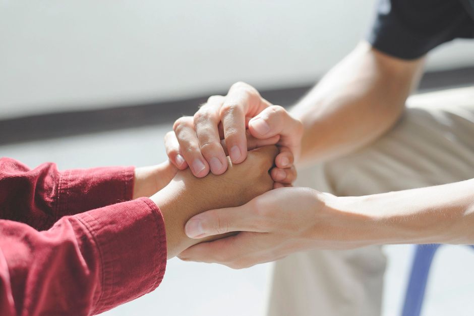 Un primer plano de una persona sosteniendo la mano de otra persona.
