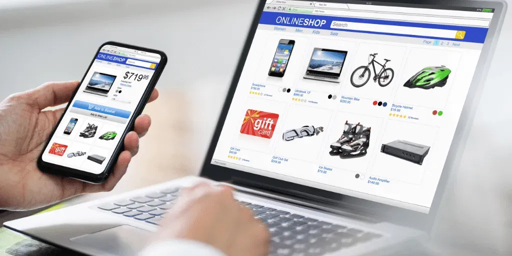 A person is holding a cell phone in front of a laptop computer. www.webtekkdesign.com