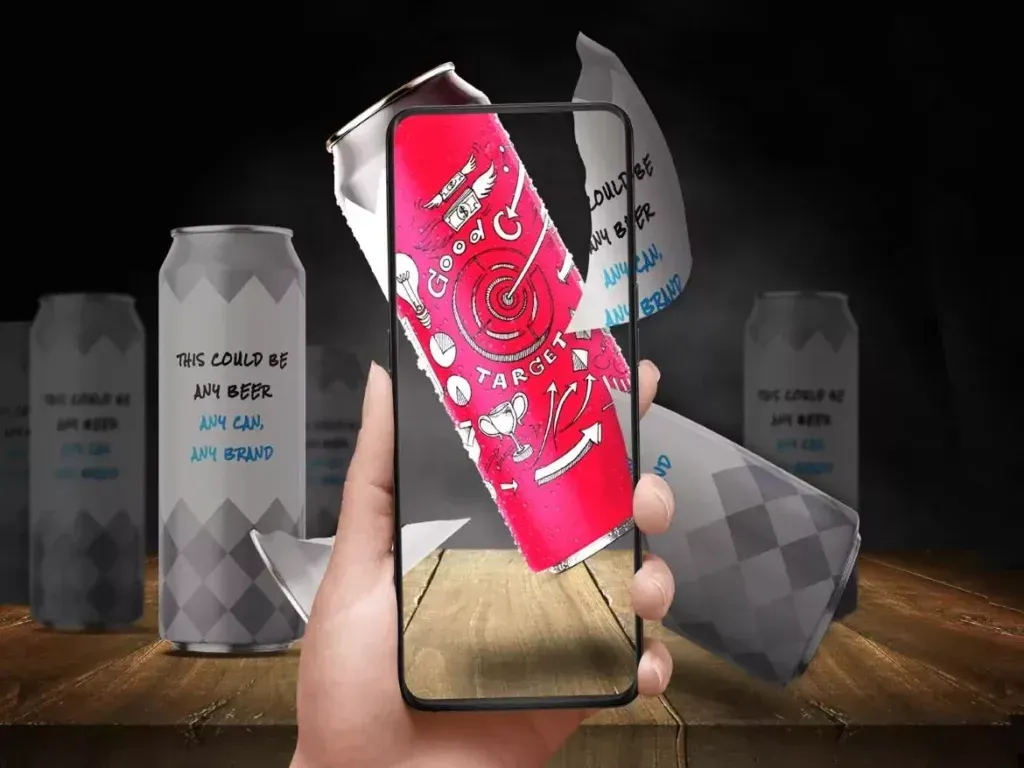 A person is holding a cell phone with a can of soda on the screen. www.webtekkdesign.com