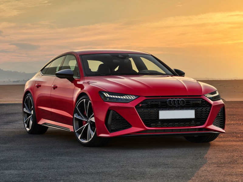 Auto sportiva Audi RS 7 rossa su una strada al tramonto.