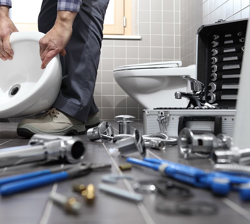 Plumber At Work In Bathroom