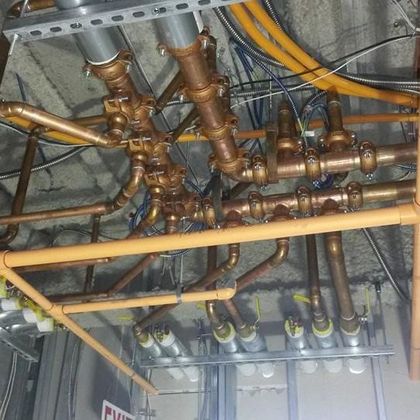 A bunch of pipes and wires are hanging from the ceiling