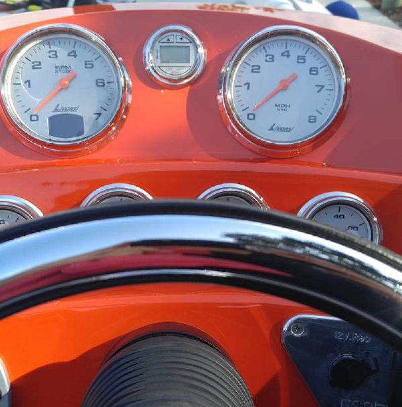 A close up of a boat dashboard with a warning button
