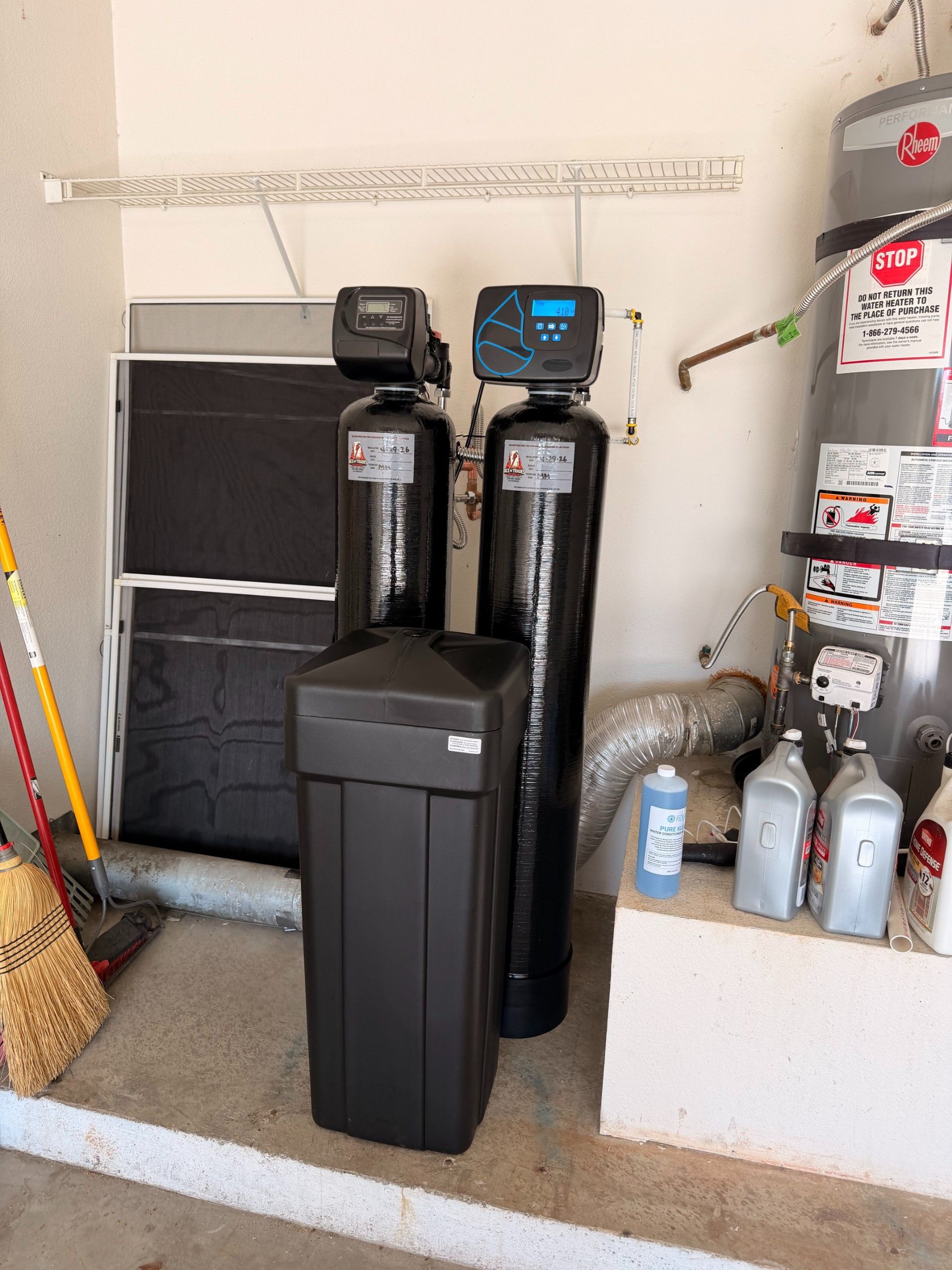Water softener and utility equipment arranged in a garage or storage area.