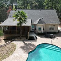 Backyard house with screened porch, patio, and turquoise swimming pool, viewed from above