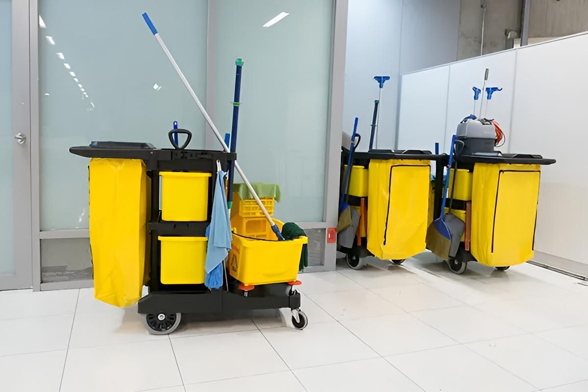 A Row of Yellow Cleaning Carts With Mops and Buckets in a Room — South Pacific Cleaning in Bentley Park, QLD