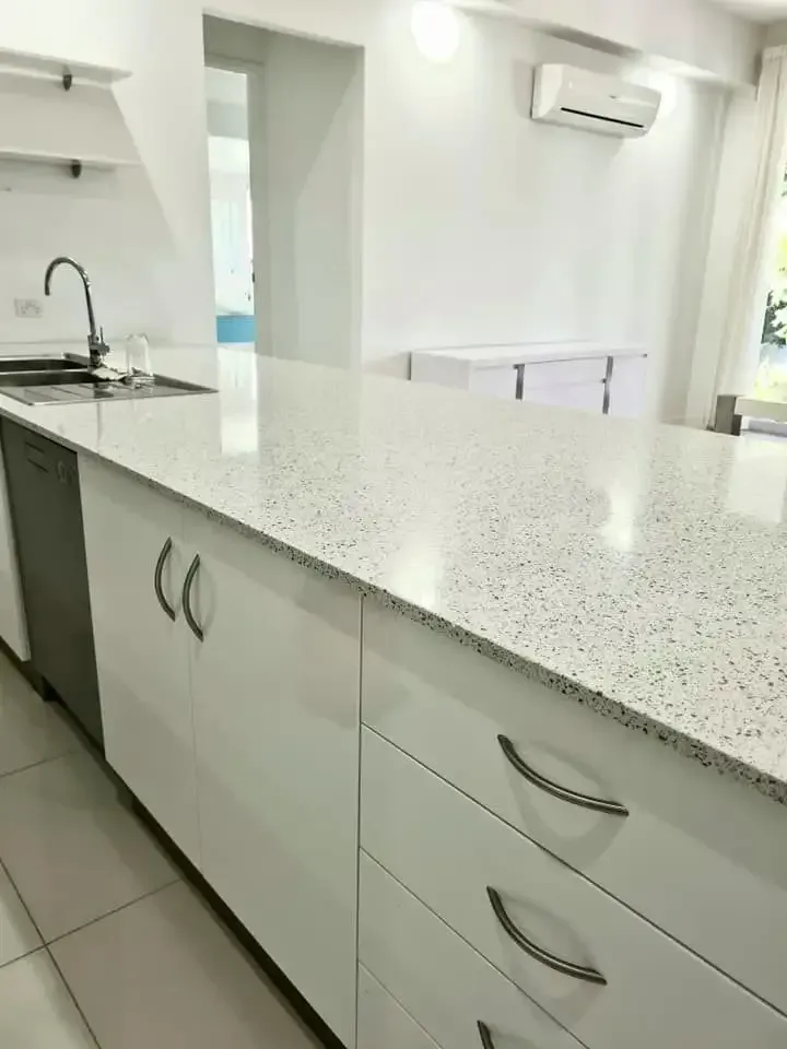 A Kitchen With White Cabinets and Granite Counter Tops — South Pacific Cleaning in Bentley Park, QLD
